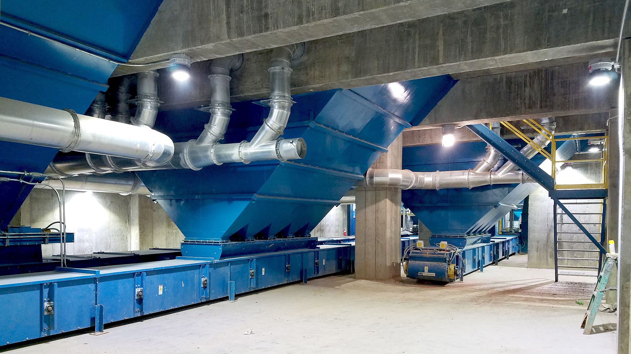 Industrial machinery with blue funnels and pipes.